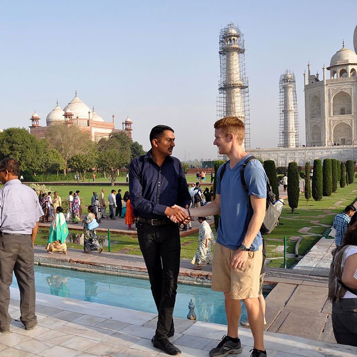 French-speaking guide at the Taj Mahal in India with tourists